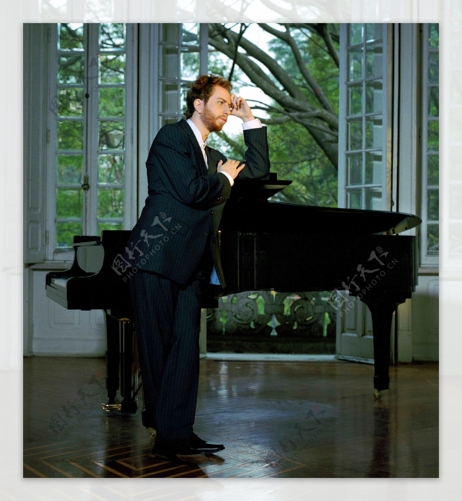 钢琴边沉思的男人图片