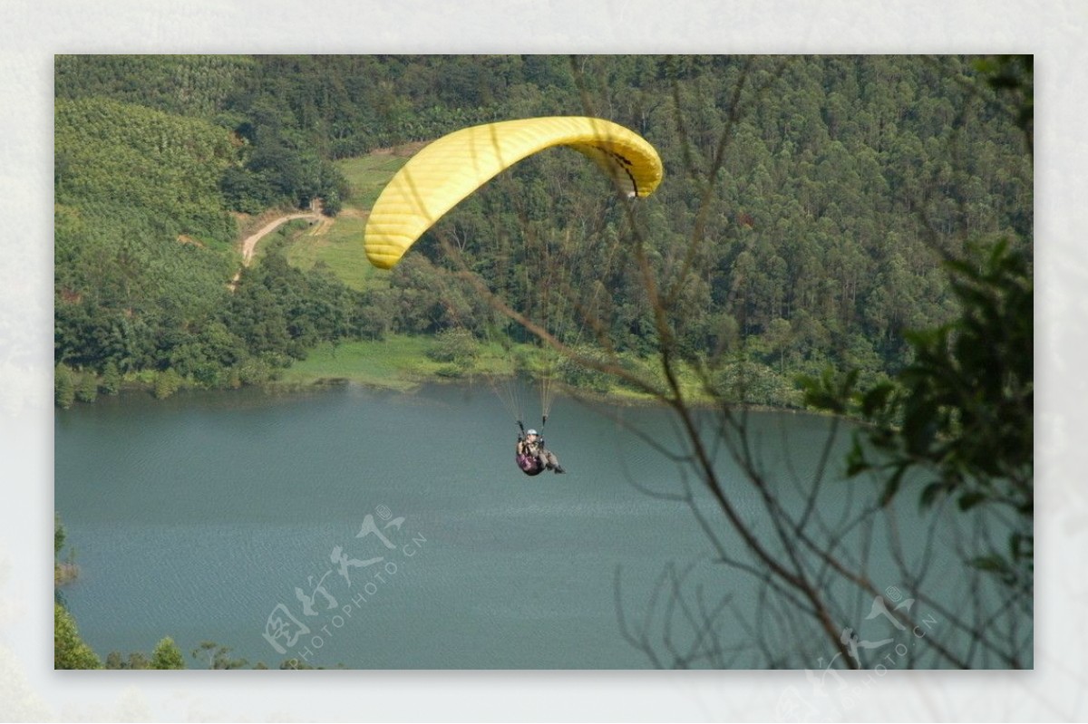 滑翔伞飞行在水面上空图片