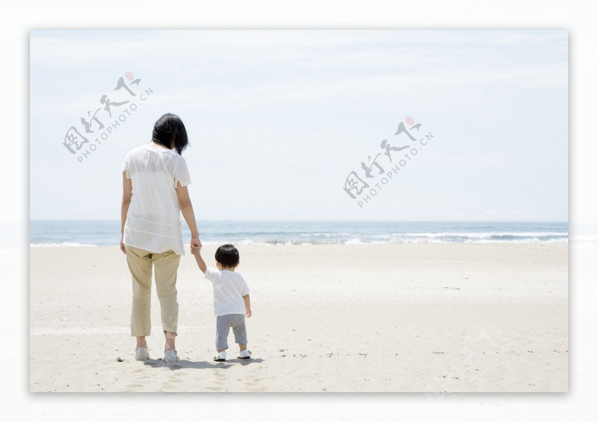 海滩沙滩散步的妈妈和孩子图片