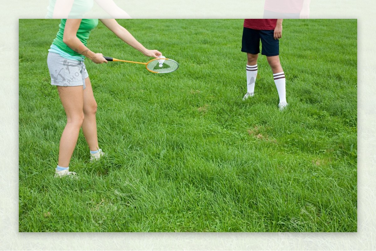草地上打羽毛球的人腿部特写图片