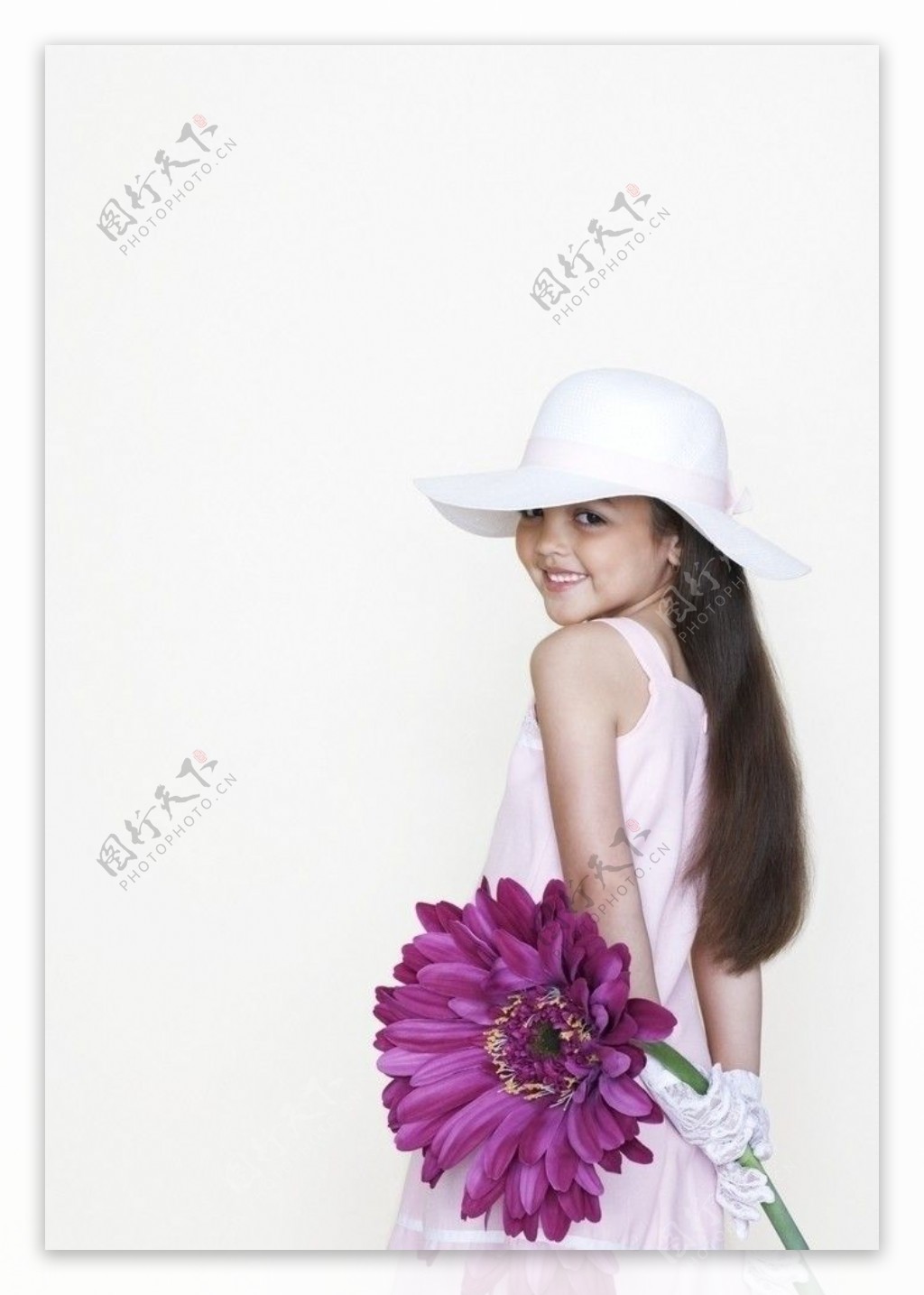 背手拿着鲜花的灿烂小女孩图片