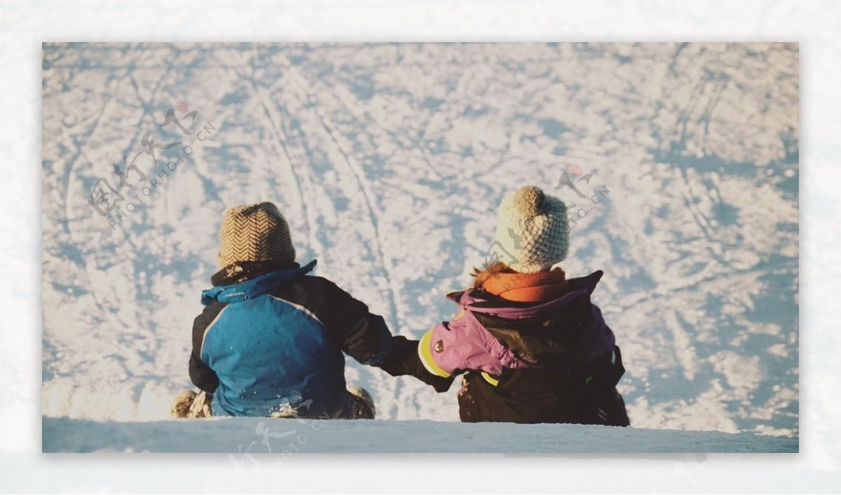 坐在雪地上的小孩背影
