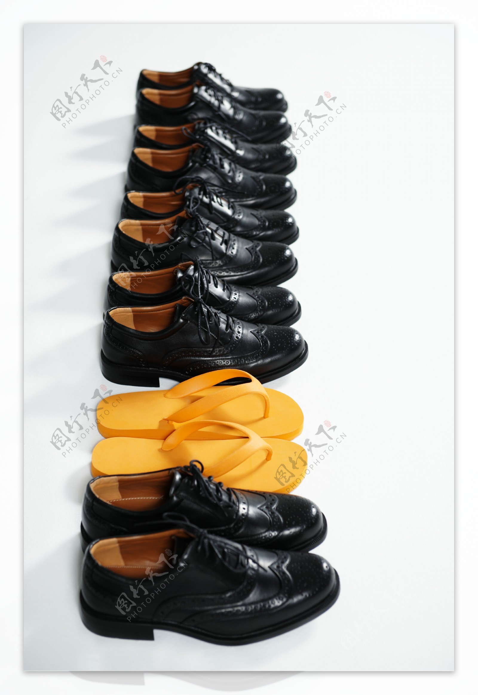 一排皮鞋中的黄色凉拖鞋图片