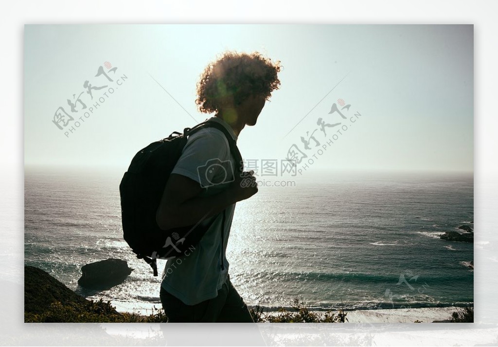 男子在白色T恤携带背包白天看海上