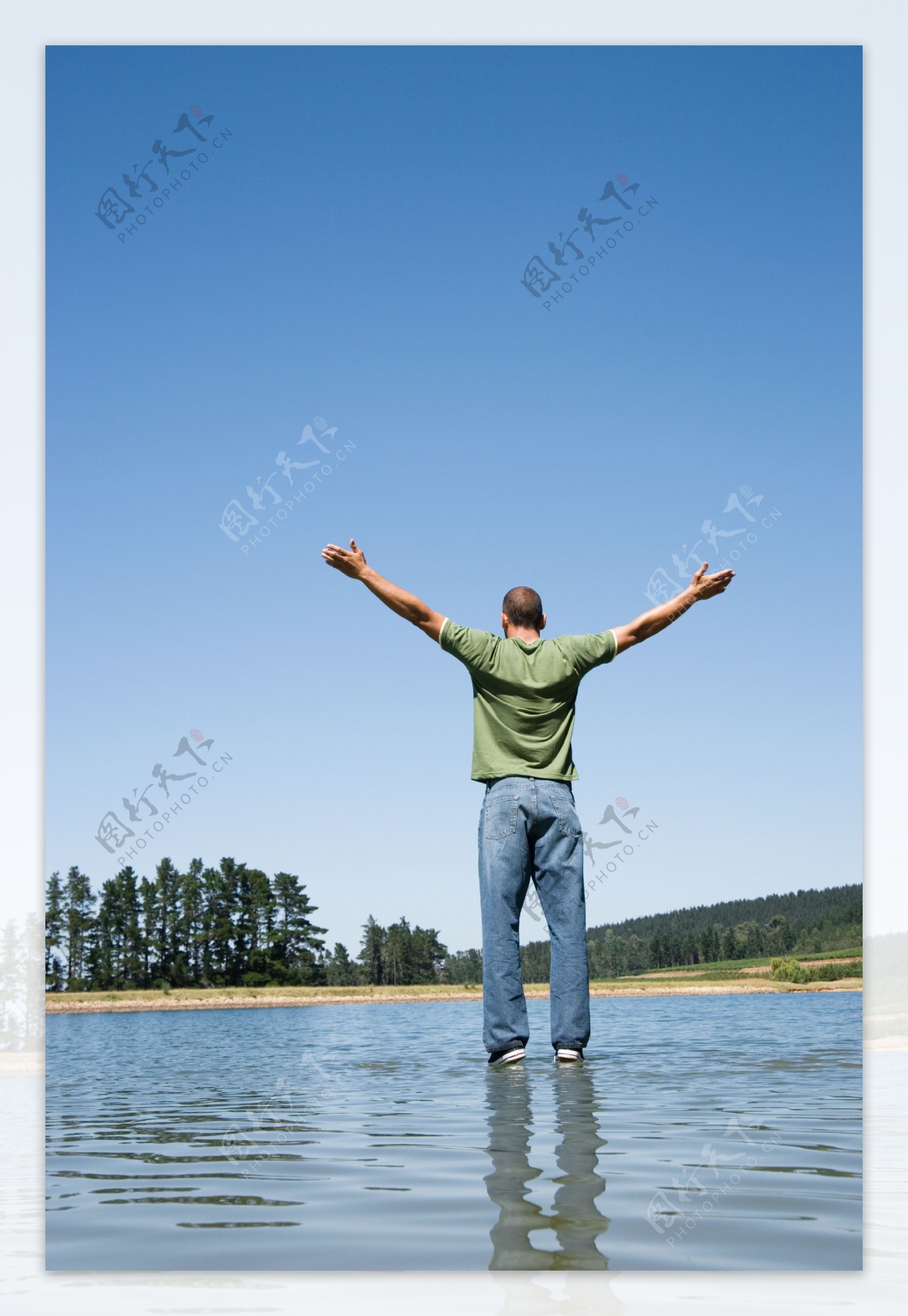 伸开双手站立在水面的男人图片