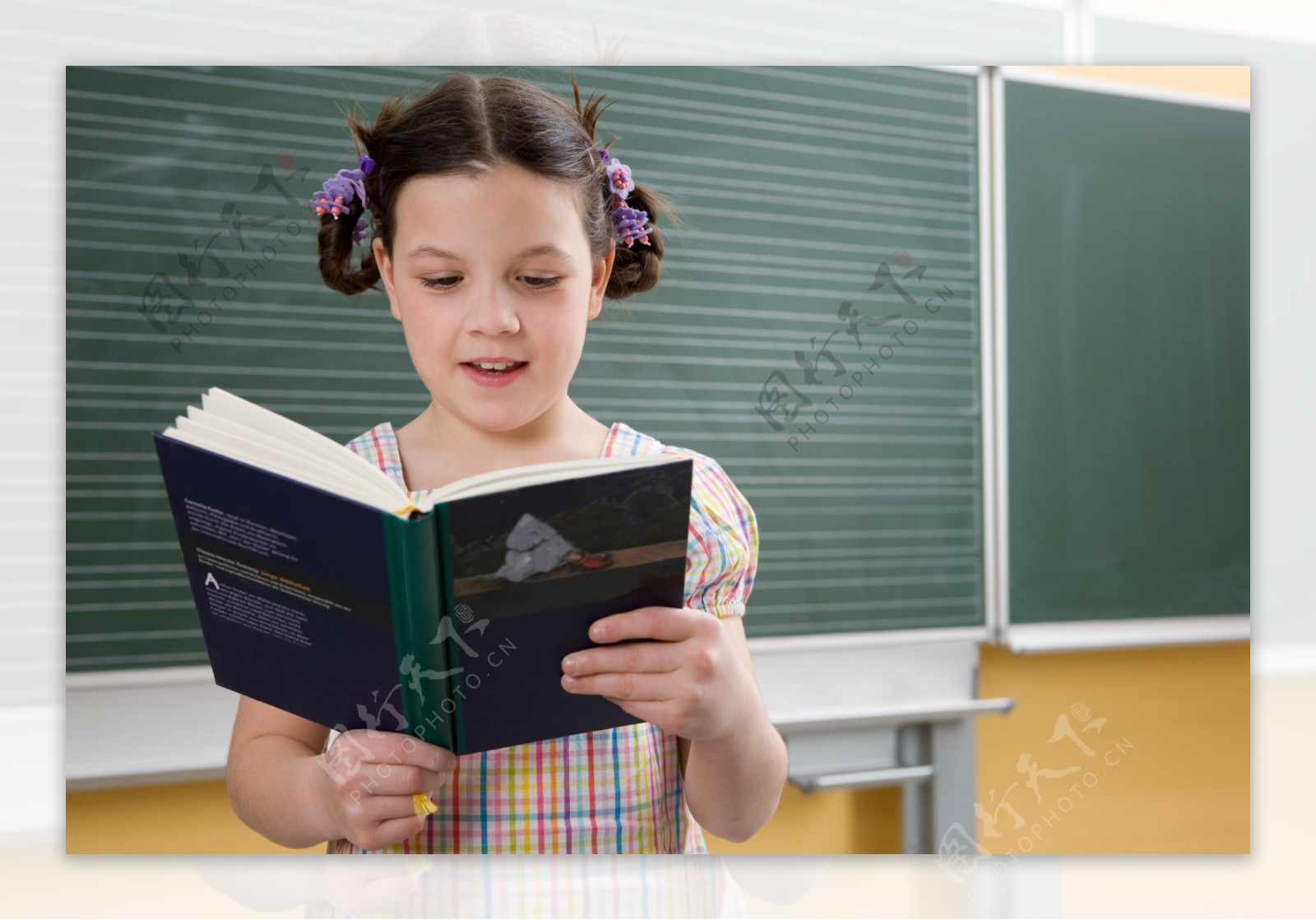 教室里黑板前看书的小女生图片