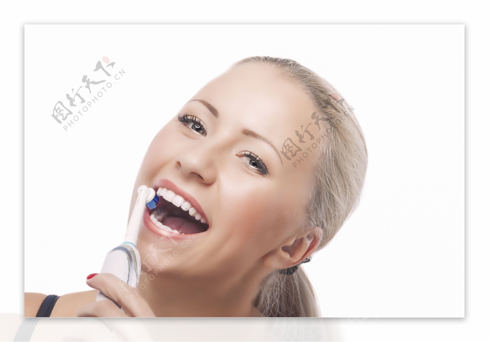 在用电动牙刷的女人图片
