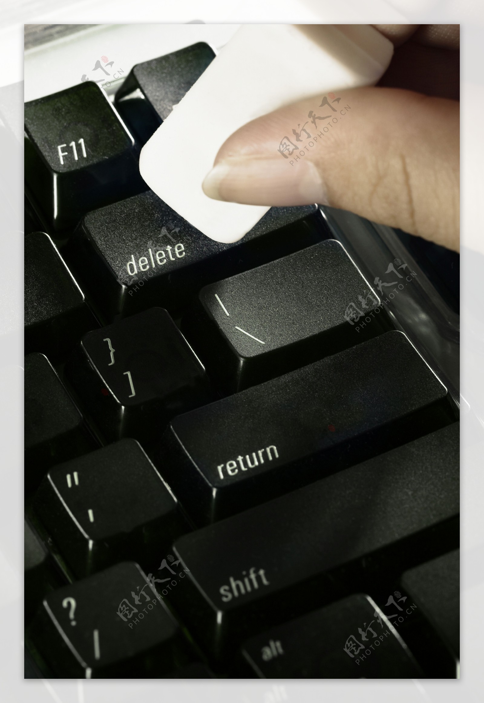 手拿白色块状清理键盘图片