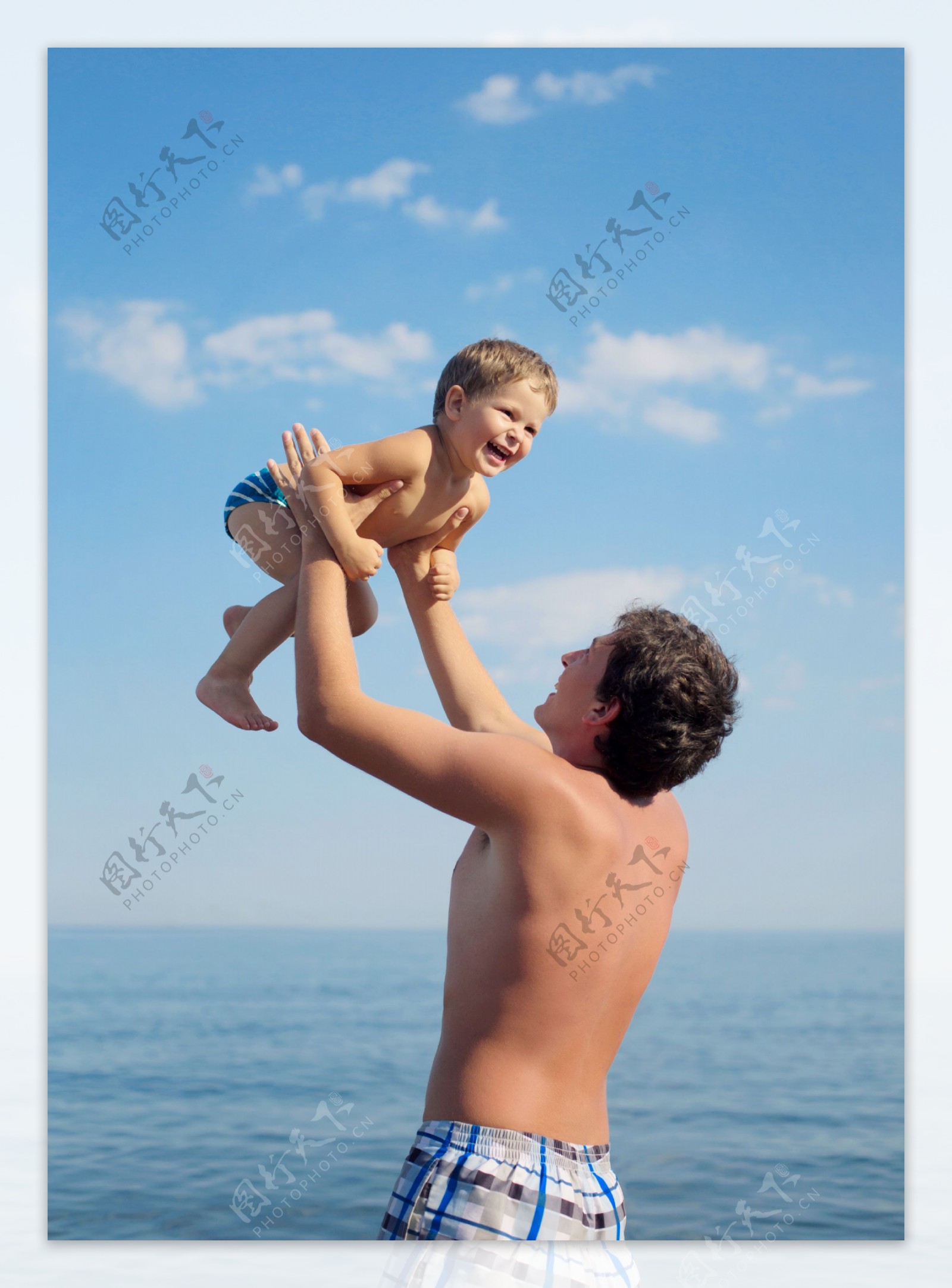 海边爸爸举起小男孩图片