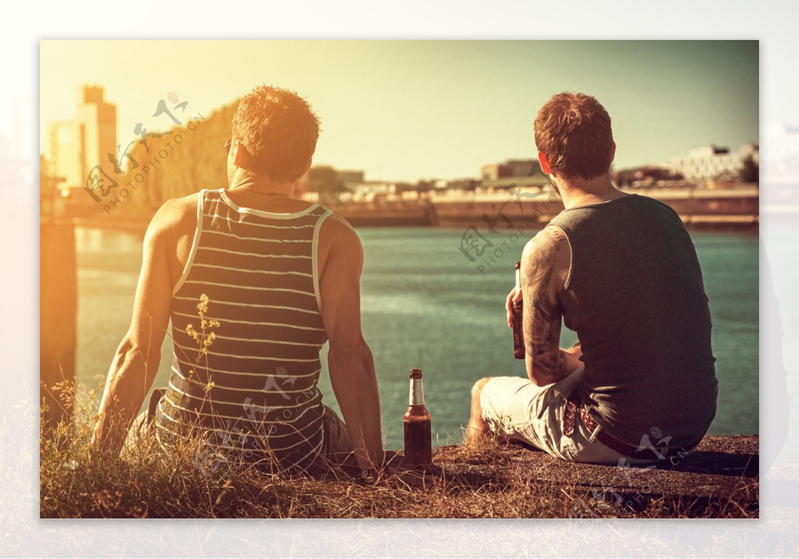 晨光下河边坐着的两个男人的背影图片