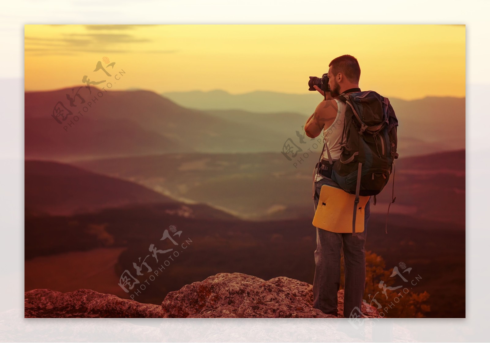 站在山顶上拍照的摄影师图片