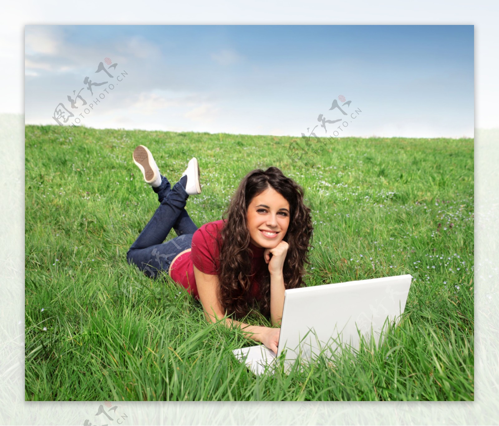 趴在草地上玩电脑的美女图片
