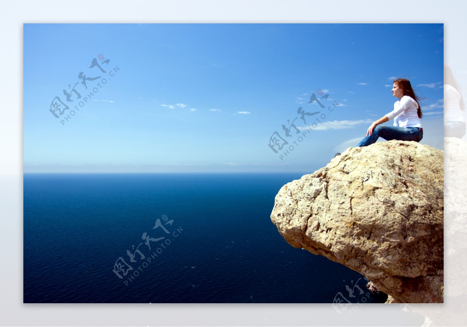 坐在岩石上的美女图片