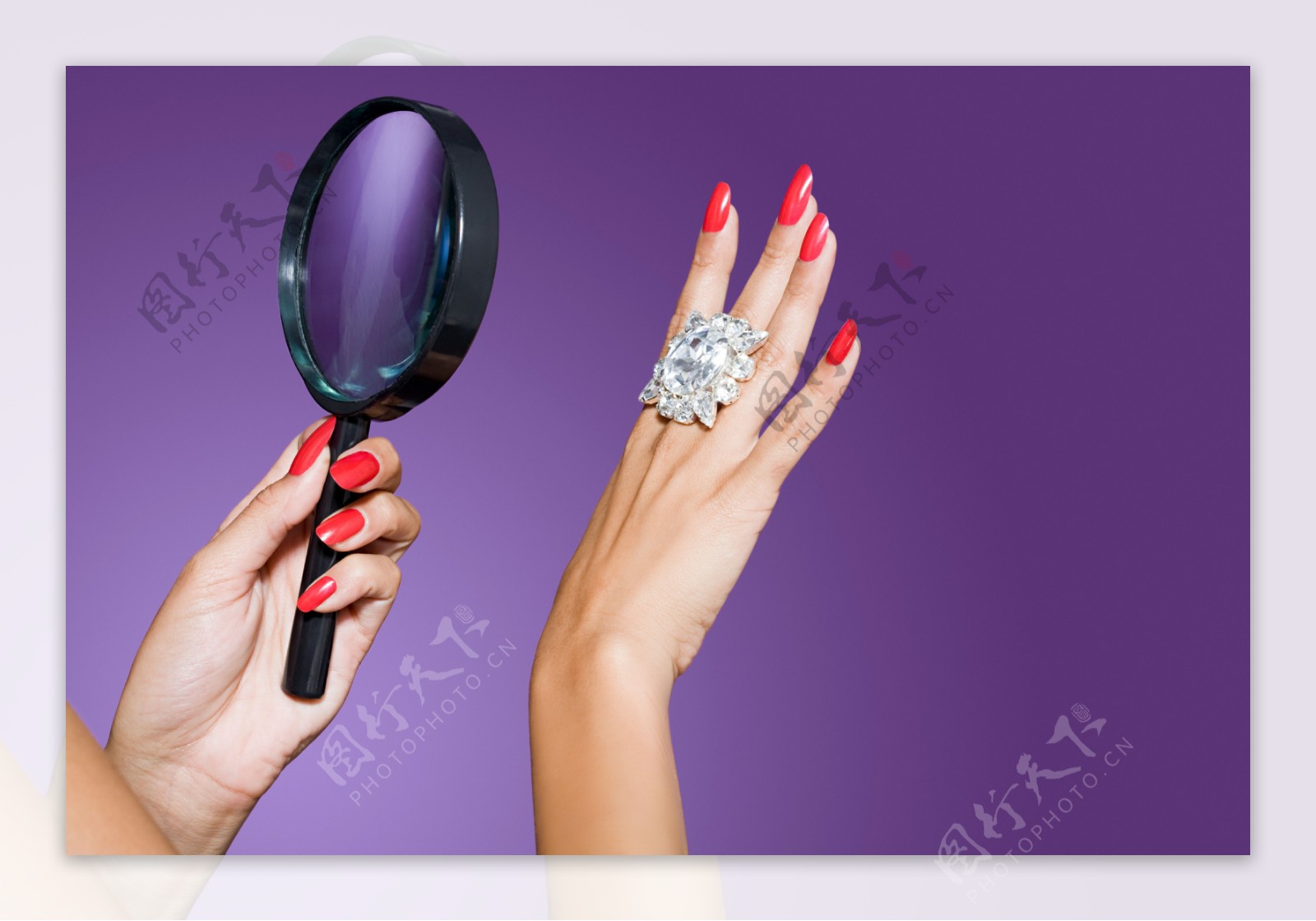 美女用放大镜研究钻石戒指图片