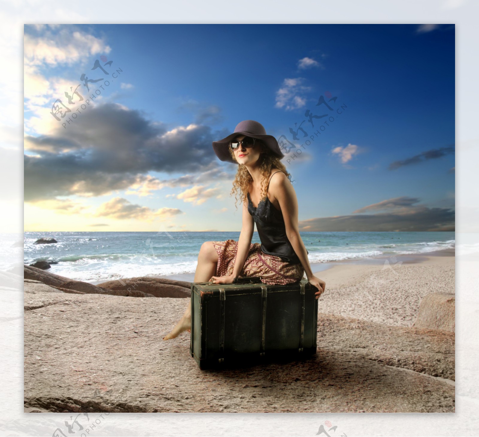 海边坐着行李箱上的外国女人图片