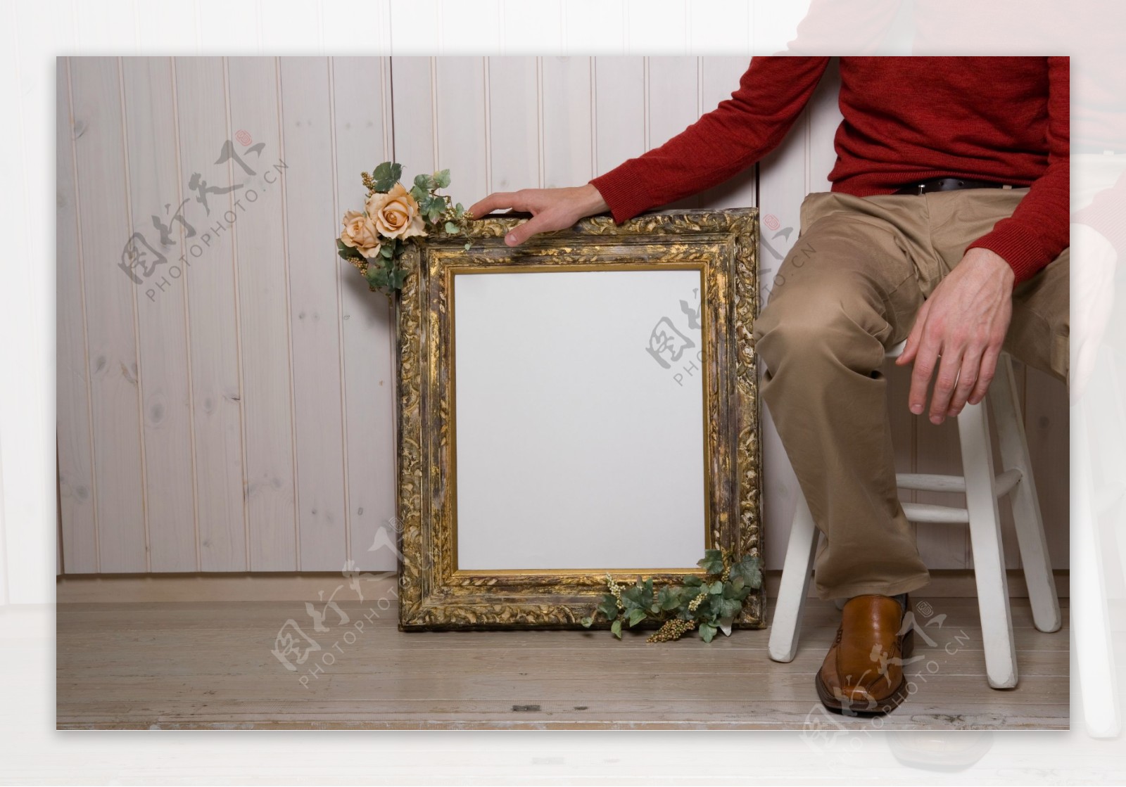 坐着的男人手拿身旁相框图片