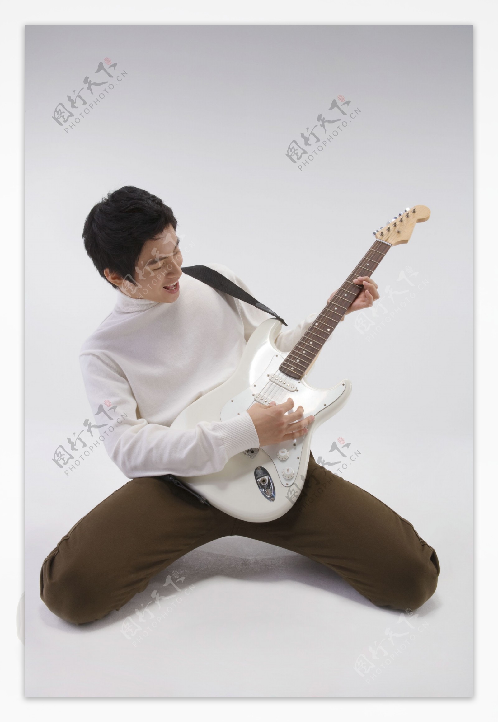 跪着弹吉他的开心男孩图片