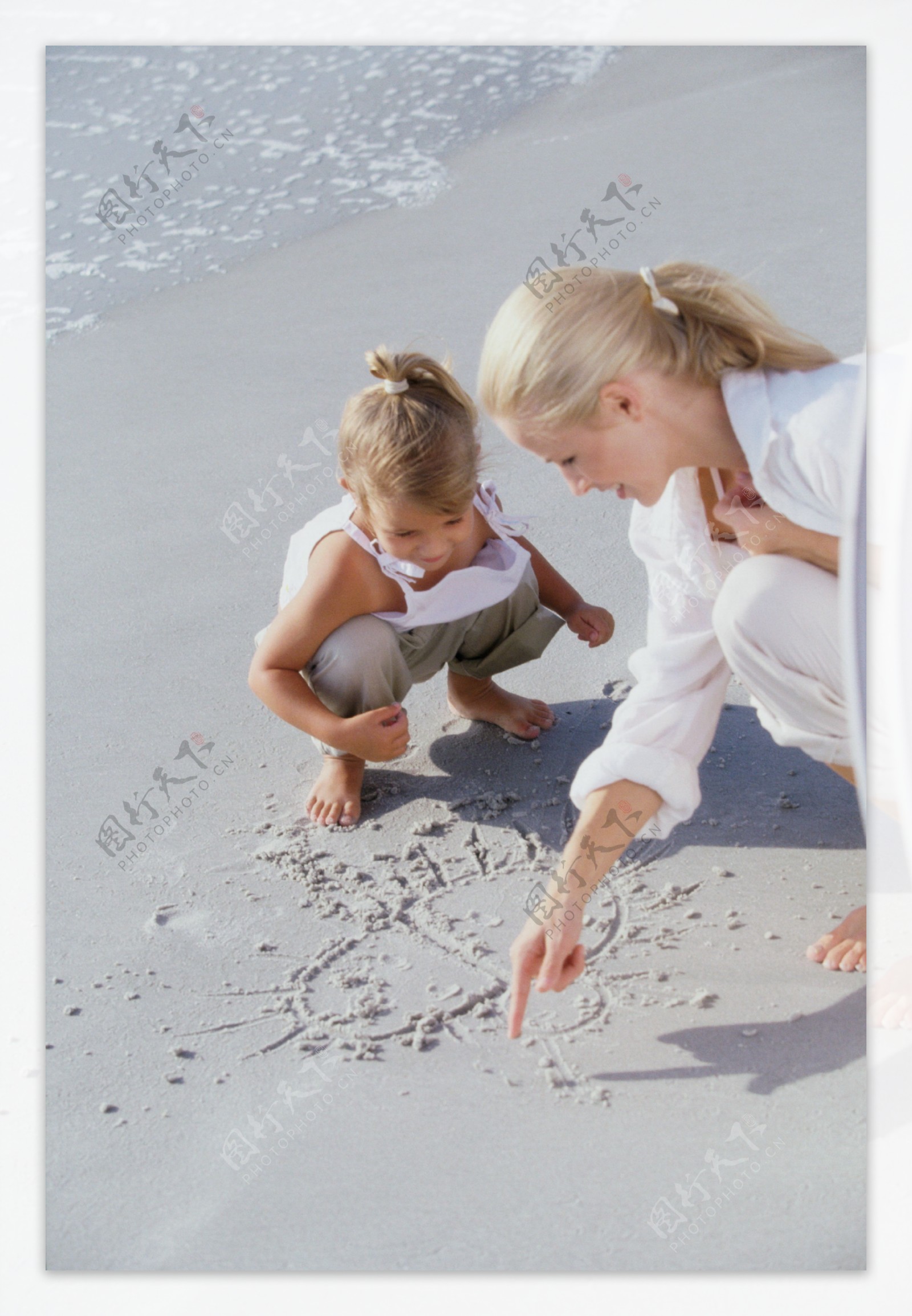 在沙滩上画画的母女图片