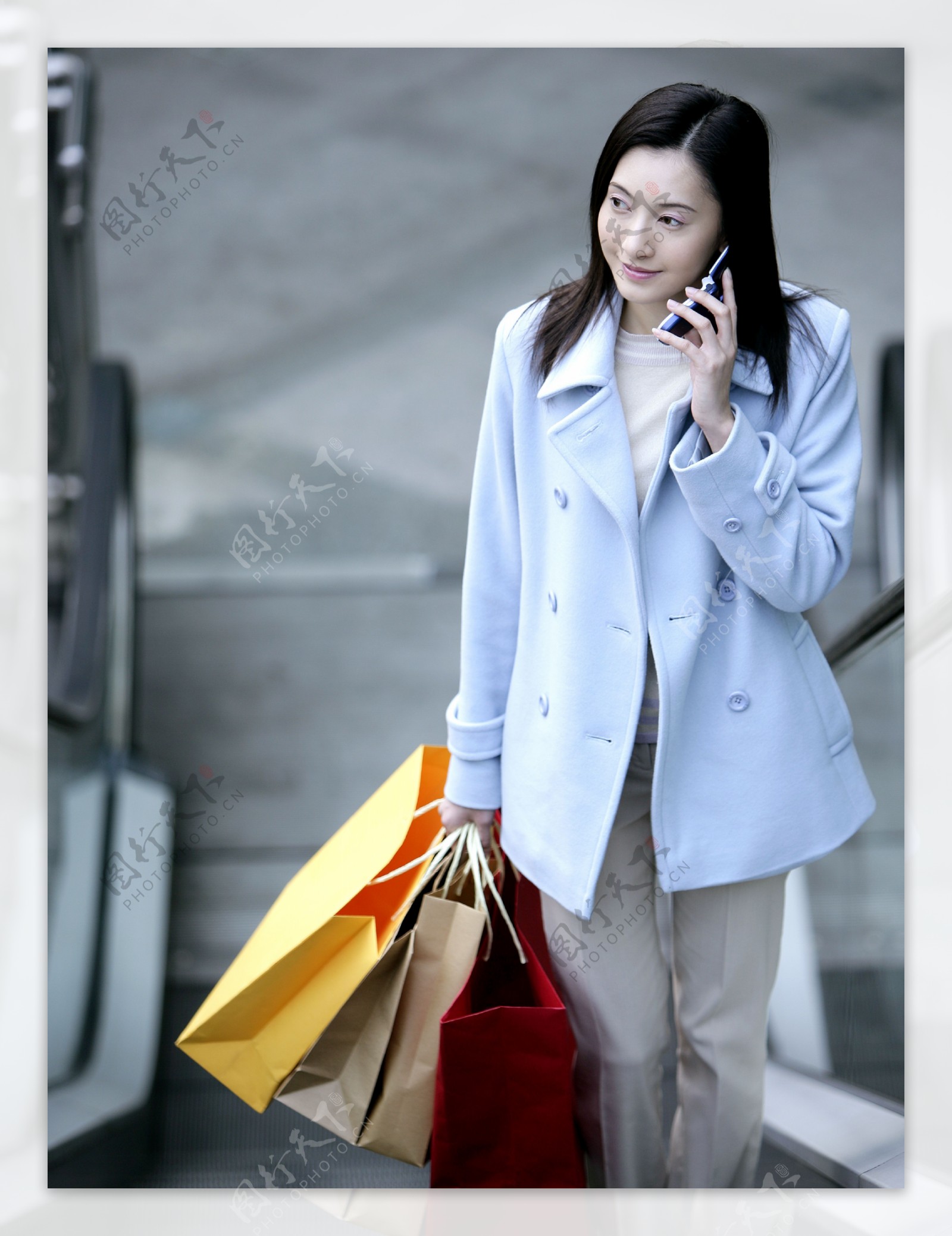 拎着个购物袋打电话的时尚女性图片图片