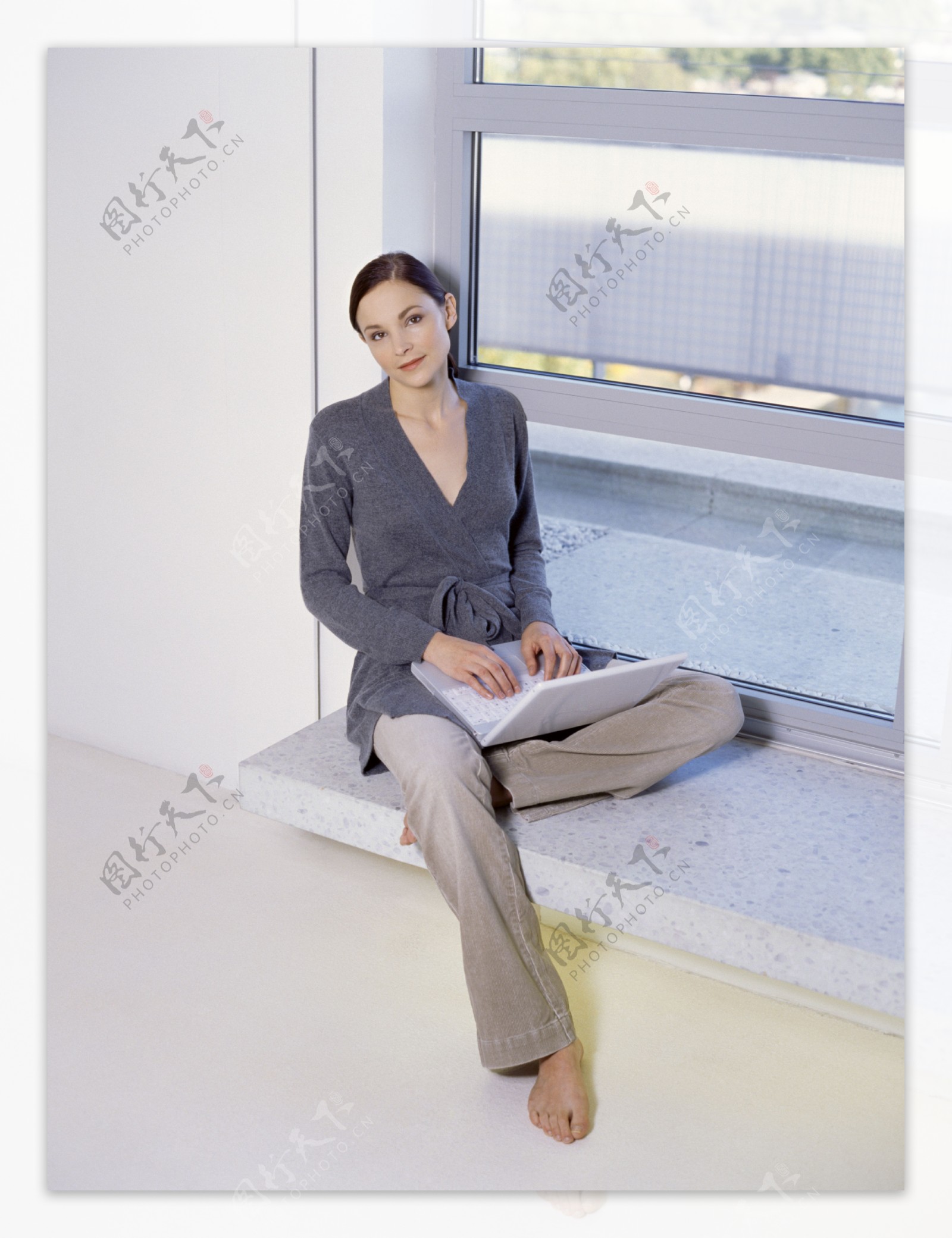 窗台上玩电脑的女人图片