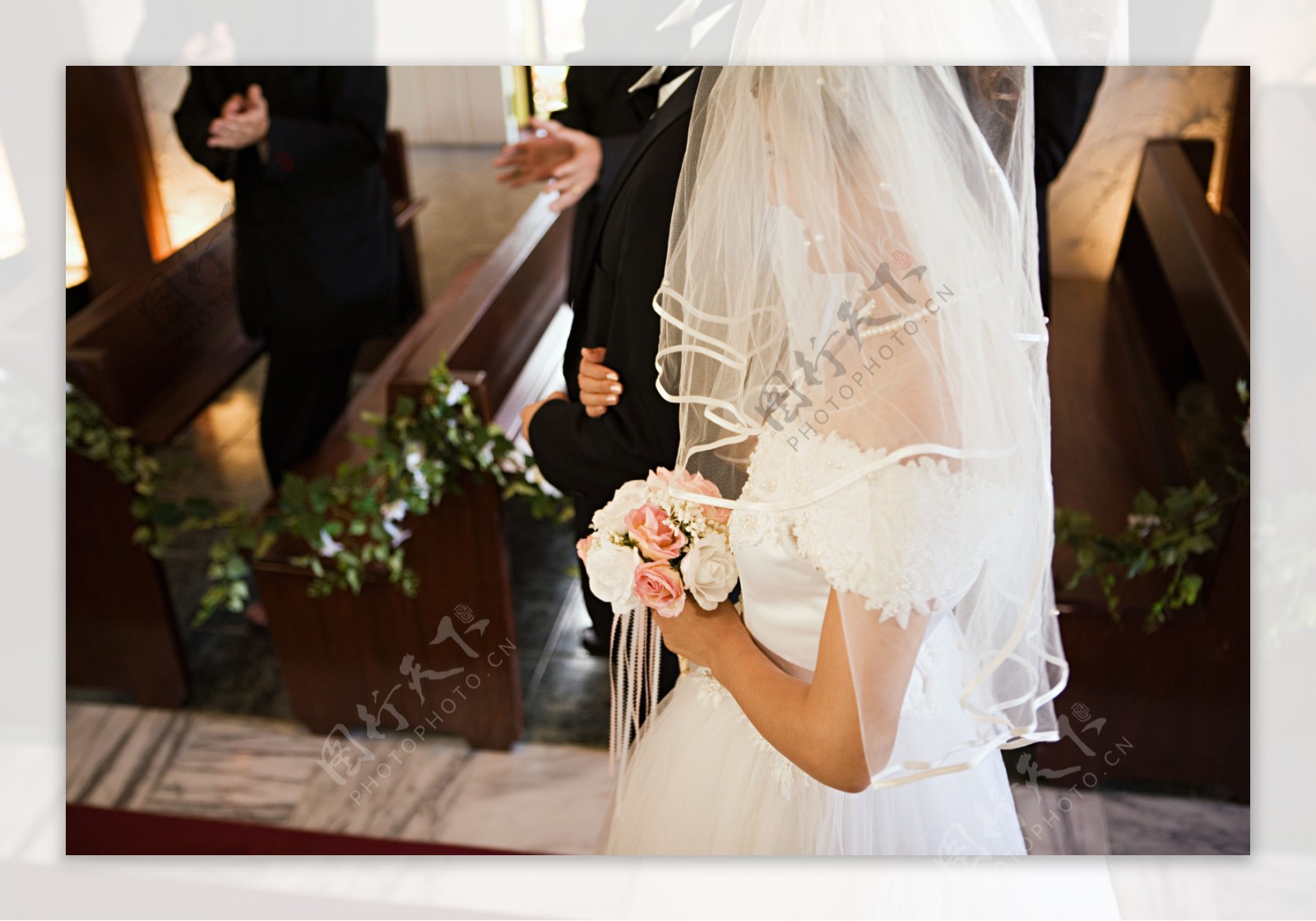 穿着白色婚纱手拿花朵幸福微笑的新娘俯视图图片